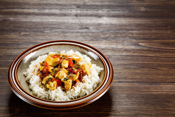 Grilled meat, white rice and vegetables on wooden table
