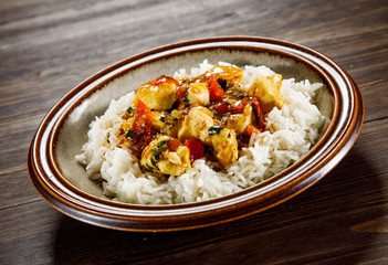 Grilled meat, white rice and vegetables on wooden table