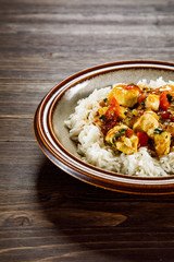 Grilled meat, white rice and vegetables on wooden table