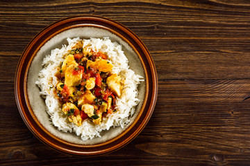 Grilled meat, white rice and vegetables on wooden table
