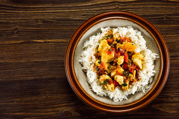 Grilled meat, white rice and vegetables on wooden table