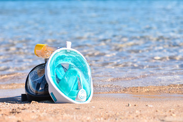 Two masks for snorkeling on the sandy beach near the sea, copy Space