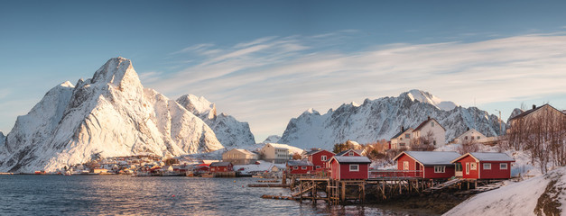 Scandinavian village with snow mountain at coastline in morning