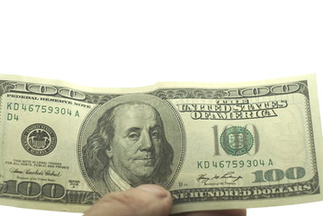 One hundred dollars in hand on a white background