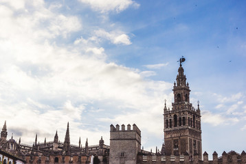 Fototapeta na wymiar View with Dome of Seville Cathedral, Giralda, Giraldillo and outer wall of Alcázar of Seville