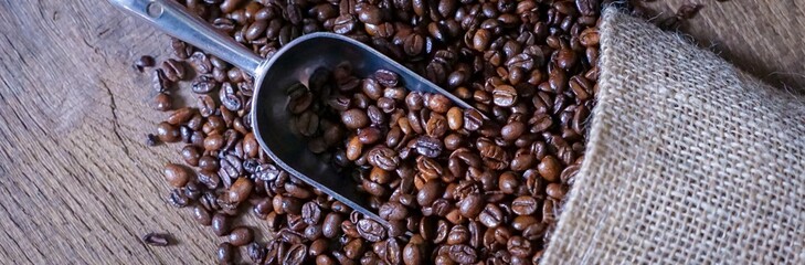 Jutesack mit ausgekippten, ganzen Kaffeebohnen und Aluschaufel zum Portionieren 