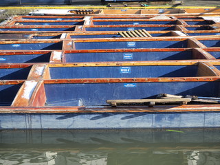 Fototapeta na wymiar Cambridge, England. Group of empty wooden boats during the winter time used for tours around the Cambridge University colleges along the river Cam