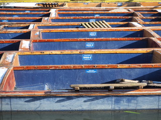 Fototapeta na wymiar Cambridge, England. Group of empty wooden boats during the winter time used for tours around the Cambridge University colleges along the river Cam