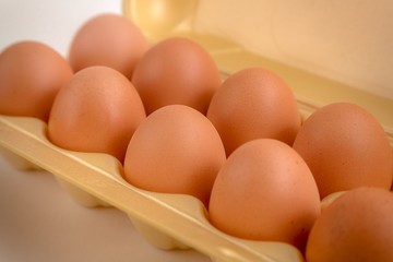 brown large chicken eggs in yellow packaging close-up