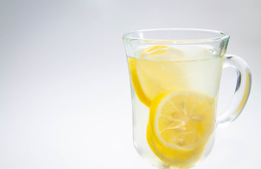lemon tea in a clear glass Cup close on a light background