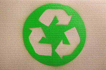 Recycling symbol painted on cardboard, top view