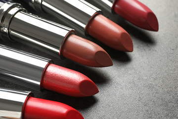 Set of different lipsticks on grey background, closeup