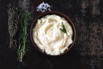 Still life with bowl of mashed potatoes and herbs