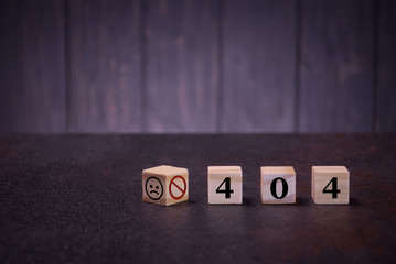 The numbers 404 and sad smile on wooden cubes, on a dark background, light wooden cubes signs, symbols signs, business office, site content