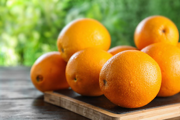Fresh juicy oranges on wooden table. Space for text