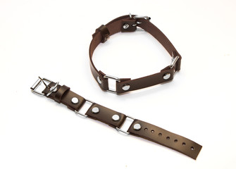 Leather brown bracelet on the hand and collar on the neck on a white background