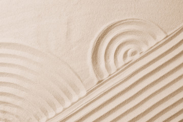 Fototapeta na wymiar Zen garden pattern on sand as background, top view. Meditation and harmony