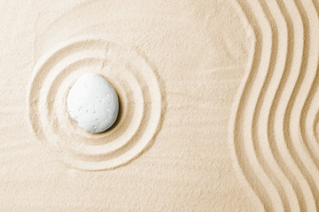 Fototapeta na wymiar Zen garden stone on sand with pattern, top view. Space for text