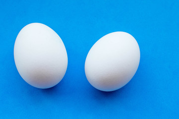 two white eggs on blue background