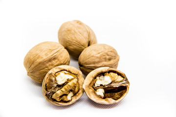 a few walnut in shell and peeled on white background