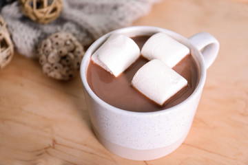 Cup of aromatic cacao with marshmallows on wooden table, closeup