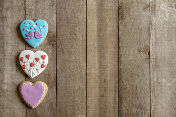 gingerbread hearts left on wooden background and text spae