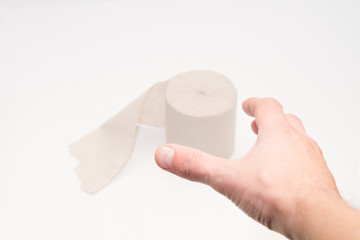 Toilet paper and hand on a white background. View from above