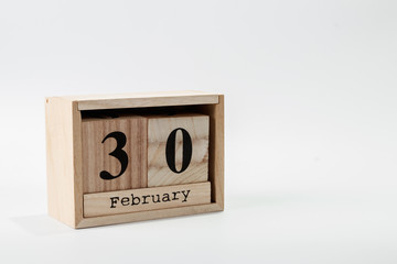 Wooden calendar February 30 on a white background