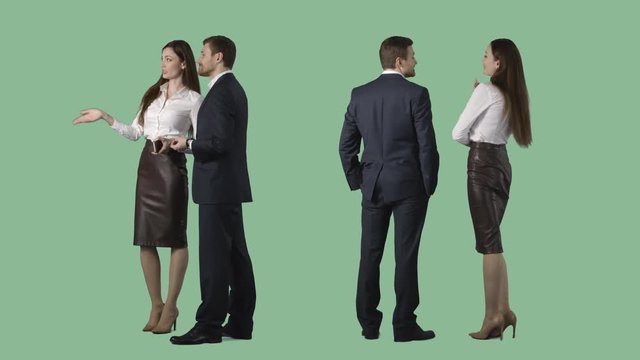 Business man and elegant female are standing, looking at something, discussing. Cut out on alpha channel background