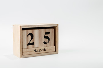 Wooden calendar March 25 on a white background