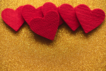 Red felt hearts on golden shiny background. Valentine's Day