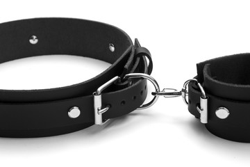 BDSM leather bracelets on the arm and leg. Isolated on white background