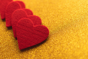 Red felt hearts on golden shiny background. Valentine's Day