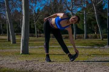 Sporty girl getting ready for workout. Young woman streching before sport.