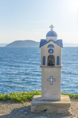 Small blue church near Neos Marmaras in Greece on summer with blue sea water in background