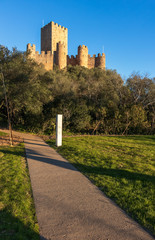 Fototapeta na wymiar Almourol, Portugal - January 12, 2019: View of the castle of Almourol from the access path from the boat to the castle, lit by the late afternoon sun and with the blue sky.
