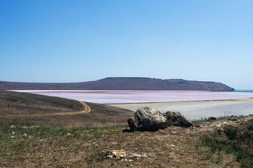 Natural summer view in clear Sunny weather, salt lake, bordering rocky shores with sparse...