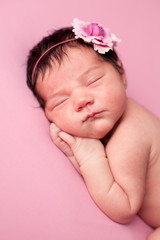 Newborn Baby Girl Sleeping on Pink Background