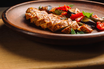 Chicken breast with grilled eggplants and peppers.
