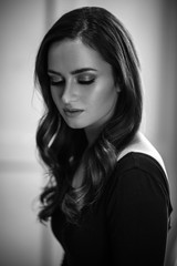 Fototapeta premium Brunette girl with healthy curly hair and natural make up . Beautiful model woman with wavy hairstyle .Care and beauty