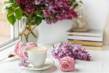 Bouquet of lilacs, cup of coffee, homemade marshmallow. Romantic spring morning. Selective focus