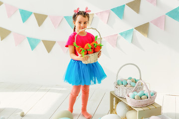 Cute little girl with bunny ears and basket of Easter eggs