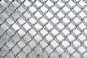 Fototapeta premium Background or pattern of frozen wire fence during winter, covered with snow and ice 