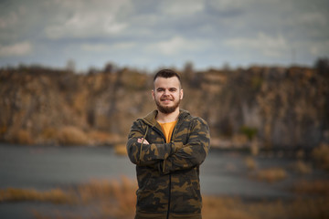 portrait of young man with beard in front of beautiful scenery
