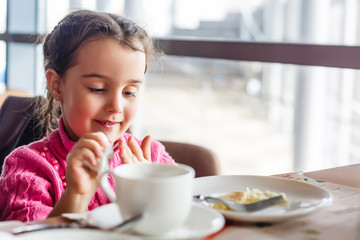cute little girl drinks tea in the morning