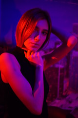 Sexy young beauty woman posing over night city dramatic red and blue neon background