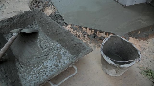 spade and tray with cement mortar on construction site.