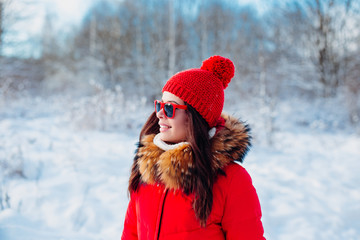 Smiling woman with red sunglasses on winter background