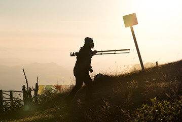 Photographer Carrying Tripod Equipment up a Mountain at Sunrise in Pokhara Nepal