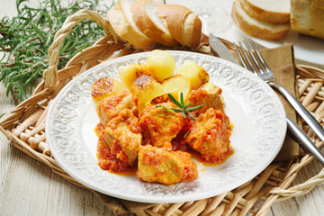Meat stew with baked potatoes on white plate